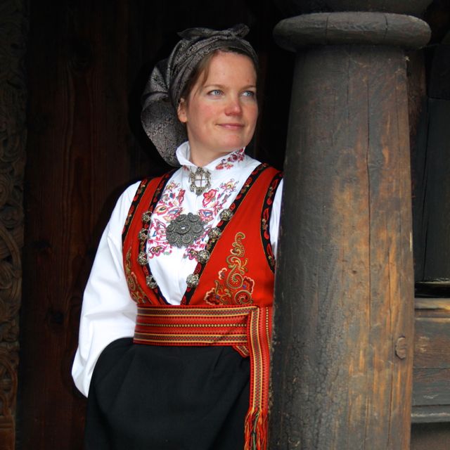 Stave church guide in traditional Norwegian dress called a "bunad"